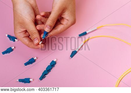 Womans Hands Hold Lc Connector Fiber Optic Patch Cord Single Mode On Pink Background