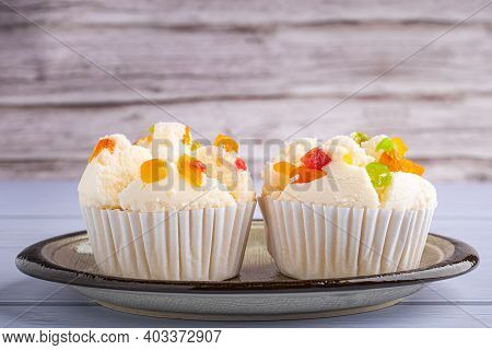 Side View Of Thai Steamed Cupcakes Topped With Dry Fruit On A Plate On Blue Cloth With Wooden Backgr