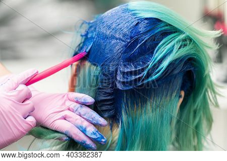 Side View Of Process Of Dyeing Hair In Unique Color. Hairdresser In Protective Glove Using Pink Brus
