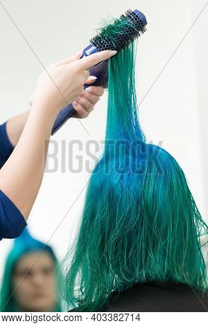 Hairdresser Combs And Dries Hair Of Emerald Color With Hairdryer After Dyeing Hair Roots In Color Of
