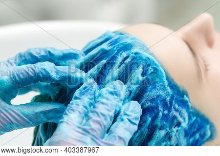Hairdresser In Protective Gloves Washes Clients Blue Hair With Shampoo For Washing After Process Of 