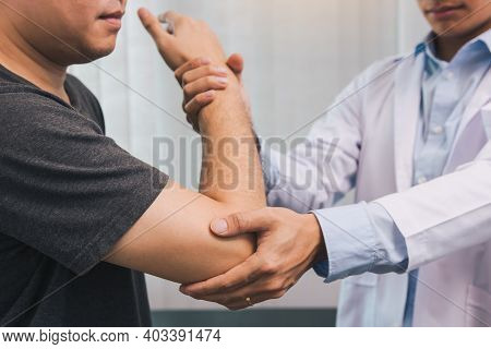 Asian Physiotherapists Check The Elbows Of Patients Who Have Undergone Orthopedic Rehabilitation.