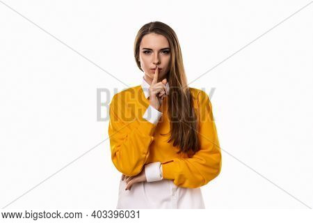 Portrait Of Young Brunette Woman Keeping Finger At Her Mouth, Saying Shh, Hush, Tsss. Silence And Se