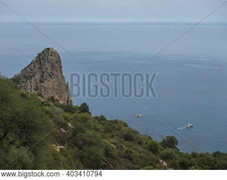 View Of Pedra Longa, Limestone Rock Pillar At Coast Gulf Of Orosei With Rescue Boat And Chopper. Sar