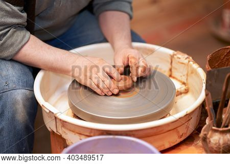 Pottery Workshop. A Cut-off Image Of A Potter Working With Clay On A Potter's Wheel.