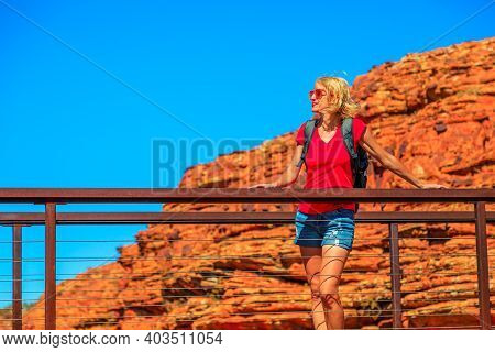 Tourist Caucasian Woman On Cotterils Bridge Who Crosses A Deep Crevice Into Kings Canyon In Watarrka