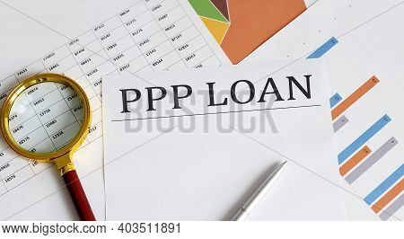 Ppp Loan Text With Magnifying Glass Lens On Office Desk Table.