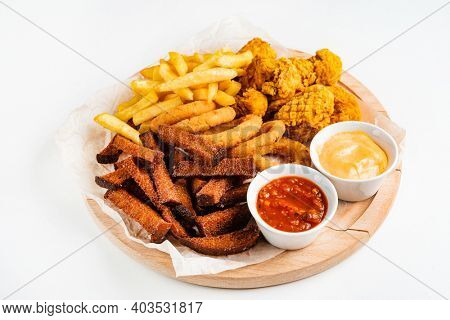 The beer plate with spicy chicken wings, calamari rings, fries onion rings, cheese balls, breaded, ketchup and mustard sauce
