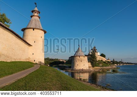 Pskov Kremlin View From River Pskova Creek. Towers, Wall And Trinity Cathedral On Background. Russia