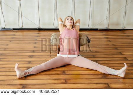 Mature Woman Doing Stretching Exercises On Yoga Backbend Bench In Studio