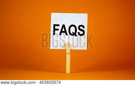 Faqs, Frequently Asked Questions Symbol. White Paper On Wooden Clothespin. Words 'faqs, Frequently A