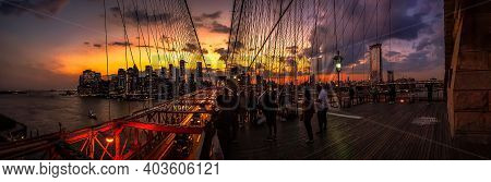 Tourist Enjoying The Twilight Skyline Over New York City From The Brooklyn Bridge As Traffic Flows F