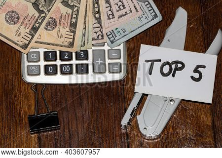 Dollars On Calculator And White Label With Text Top 5 On It.