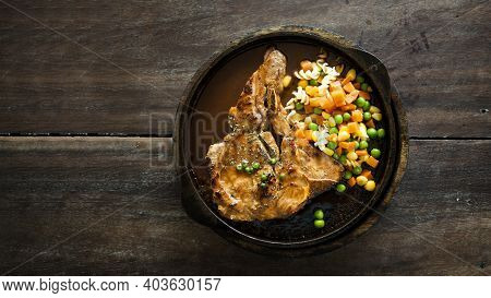 Pork Stake Serve On Hot Pan With Gravy Suace With Green Bean Carrot And Corn From Top View On Wood T