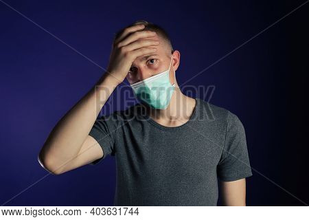 Caucasian Sick Man In A Medical Gause Mask With Palm On His Head.