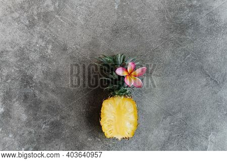 Pineapple And Frangipania On A Stone Table. Tropical Fruits. Top View. Free Space For Your Text.