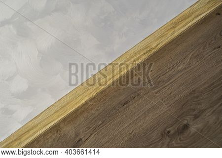Laminate With Plastic Baseboard With A Wooden Texture. Newly Installed Wooden Laminate Flooring And 