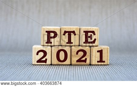 Pte (pearson Test English) 2021 - Word On Wooden Cubes On A Gray Background. Business And Finance Co