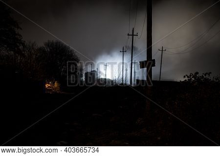 Night Street Country Road With Buildings And Fences Covered In Fog Lamp . Or Mysterious Night In Aze