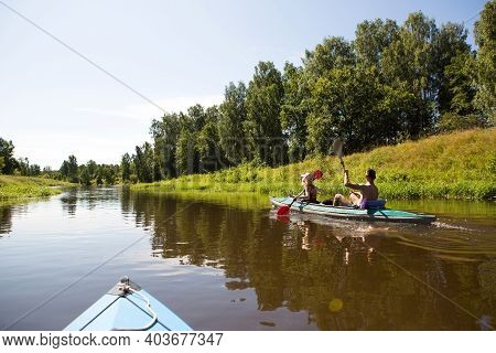 A Couple Of Men And Women Kayak On The River In The Summer. Active Recreation, Family Travel, Extrem
