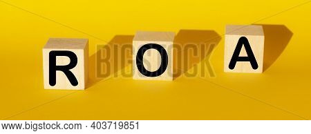 Roa Return On Asset Acronym On Wooden Cubes On Yellow Background. Business
