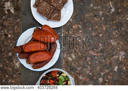 Sausages, Bread And Salad - Food To Prepaire On A Fire. Concept Of Outdoor Cooking.