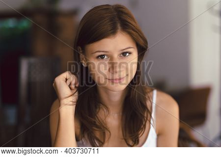 Young Girl In Cafe Looking Right To The Camera And Smiling