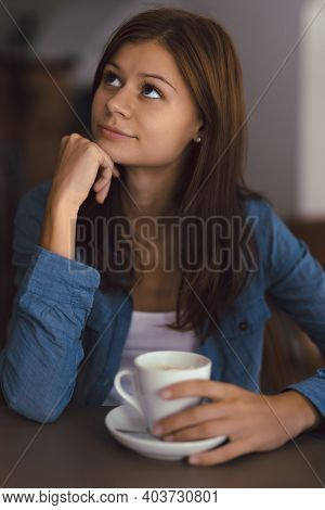 Young Girl In Cafe With Cup Of Hot Chocolade Thinking