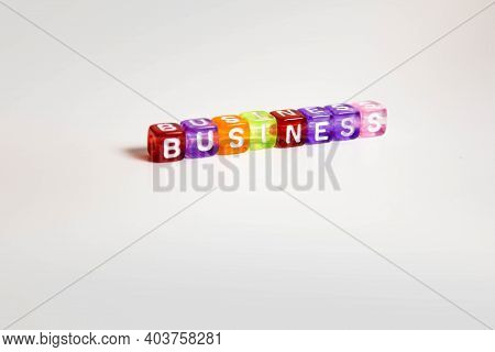 The Word Business Is Written On Colorful Cubes On A Gray Background. Style