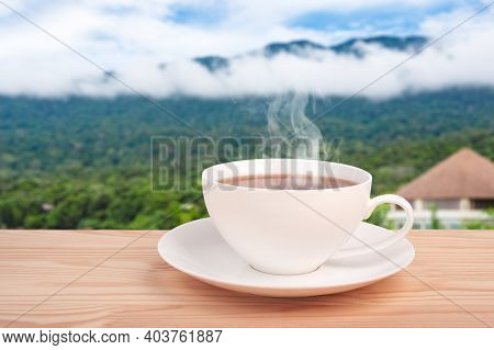Tea Cup With Organic Tea Leaf On The Wooden Table And Tea Plantations. Warm Cup Of Tea. Space For Te