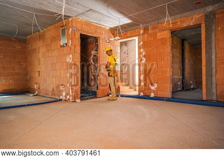 Newly Built Commercial Concrete Blocks Building. Caucasian Construction Worker In His 40s Wearing He
