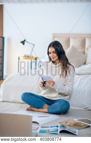Dark-haired Young Woman Cutting Pistures From Magazines And Making A Wishlist