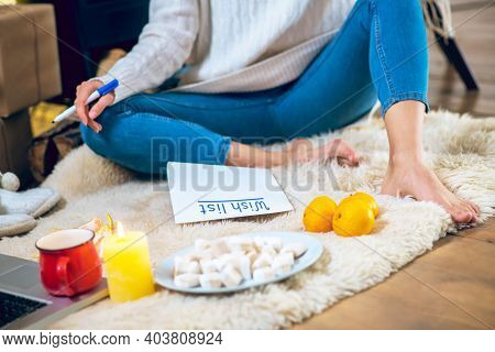 Woman Sitting On The Floor And Prepapring Her Wishlist