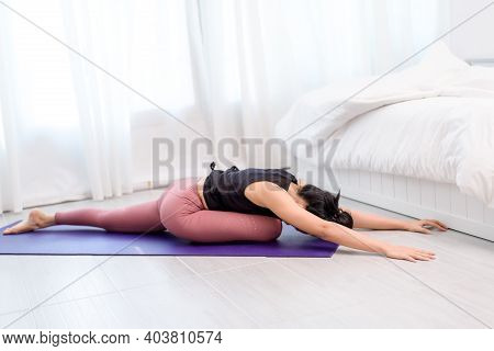 Young Woman Do Yoga In A Bed Room