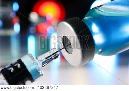 Filling Syringe With Vaccine From Vial On Blurred Background, Closeup