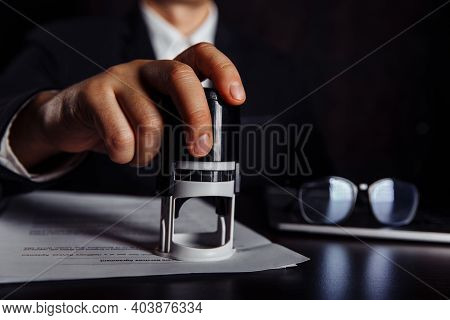 Close-up Of Businessman Hand Using Stamper On Document