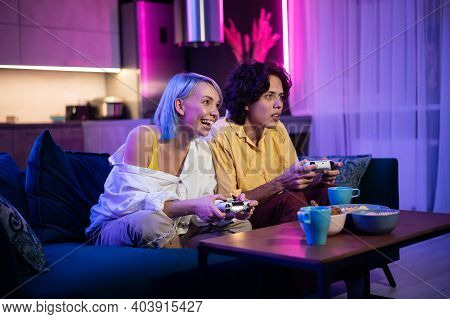 Handsome Young Man Teaching How To Play The Video Games To His Girlfriend, On The Couch, Concept Abo