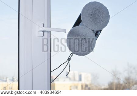Downside Of Vacuum Cleaner Robot For Washing Glass Window On Clean Blue Sky. Smart Robot Assistant A