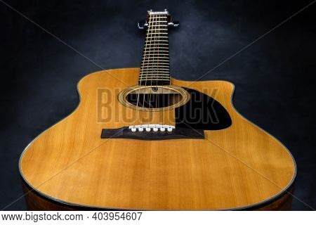 Acoustic Guitar With Yellow Deck And Black Pickguard On Isolated Black Background