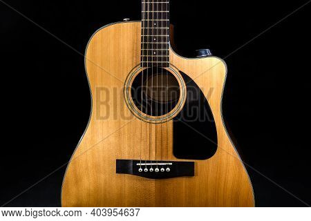 Body Of A Classic Acoustic Six-string Guitar With A Yellow Sound Board And Black Pickguard On Isolat