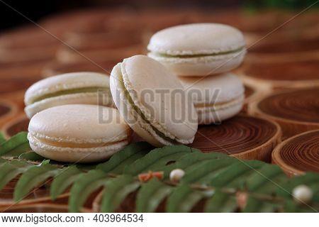 White Delicate Lowly Macaroons On A Wooden Background. The Pastel Tone Of The Cream Inside The Frenc