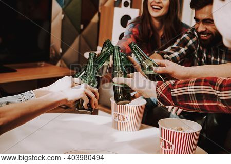 Group Of Friends Gathering Around Coffee Table At Home. Friends Gathered At The Table And Drinking B