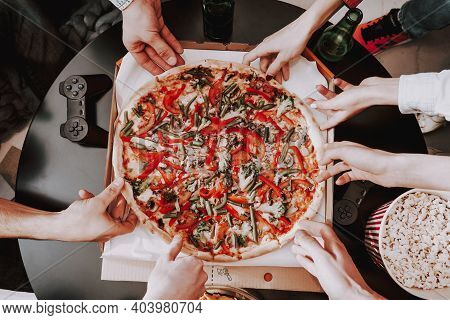 Group Of Friends Gathering Around Coffee Table At Home. Friends Gathered At The Table And Drinking B
