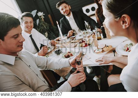 Group Of Friends Gathering Around Coffee Table At Home. Friends Gathered At The Table And Drinking B