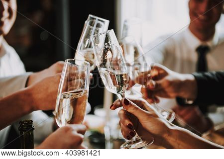 Group Of Friends Gathering Around Coffee Table At Home. Friends Gathered At The Table And Drinking B