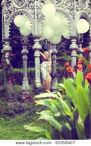 Sentiment. Beautiful Relaxed Blonde Holding Air Balloons In The Garden