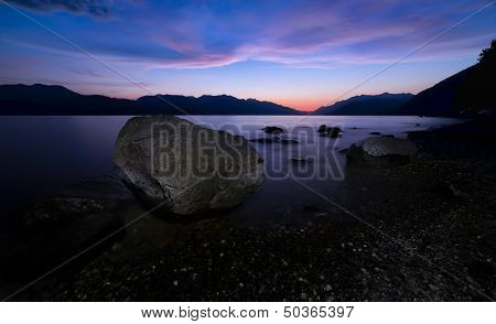 Large Rock Along Lake Shore At Night