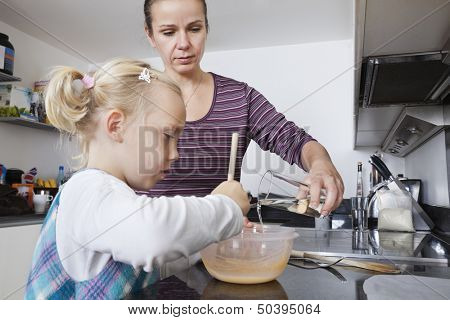 Mother and daughter cooking in kitchen
