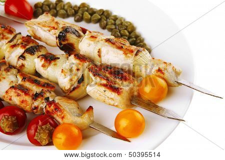 pork shish kebab on white platter with vegetables