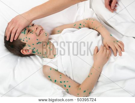 sick boy and mother hand touches the forehead